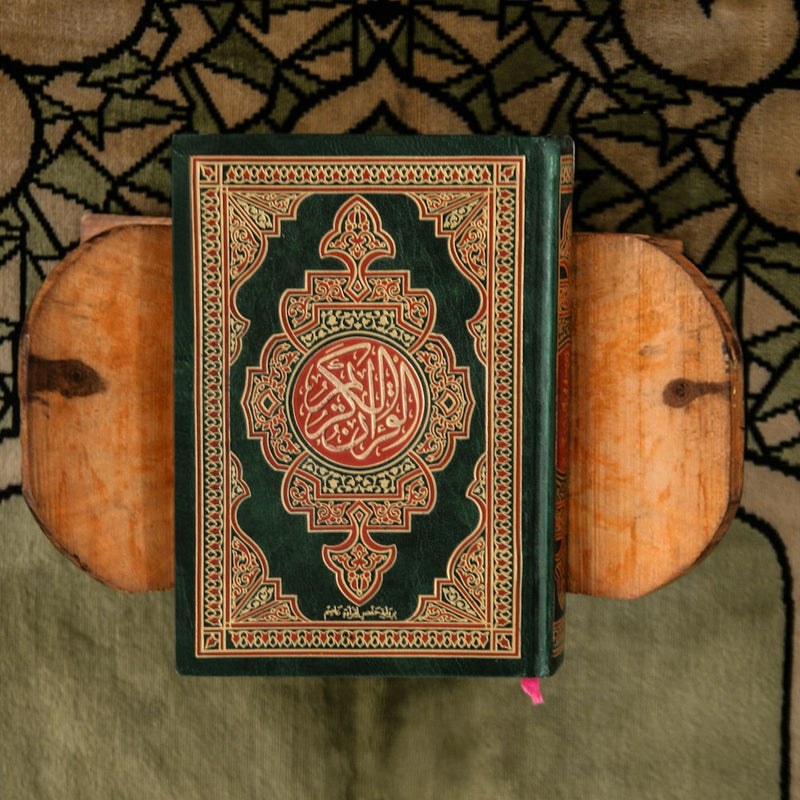 Quran auf einem Holzständer auf einem Gebetsteppich